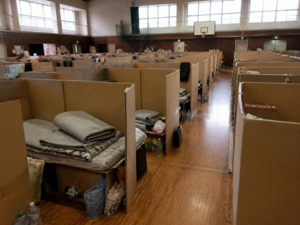 避難所の体育館。段ボールの衝立てで区切られた狭い居住スペースが並んでいる（イメージ）